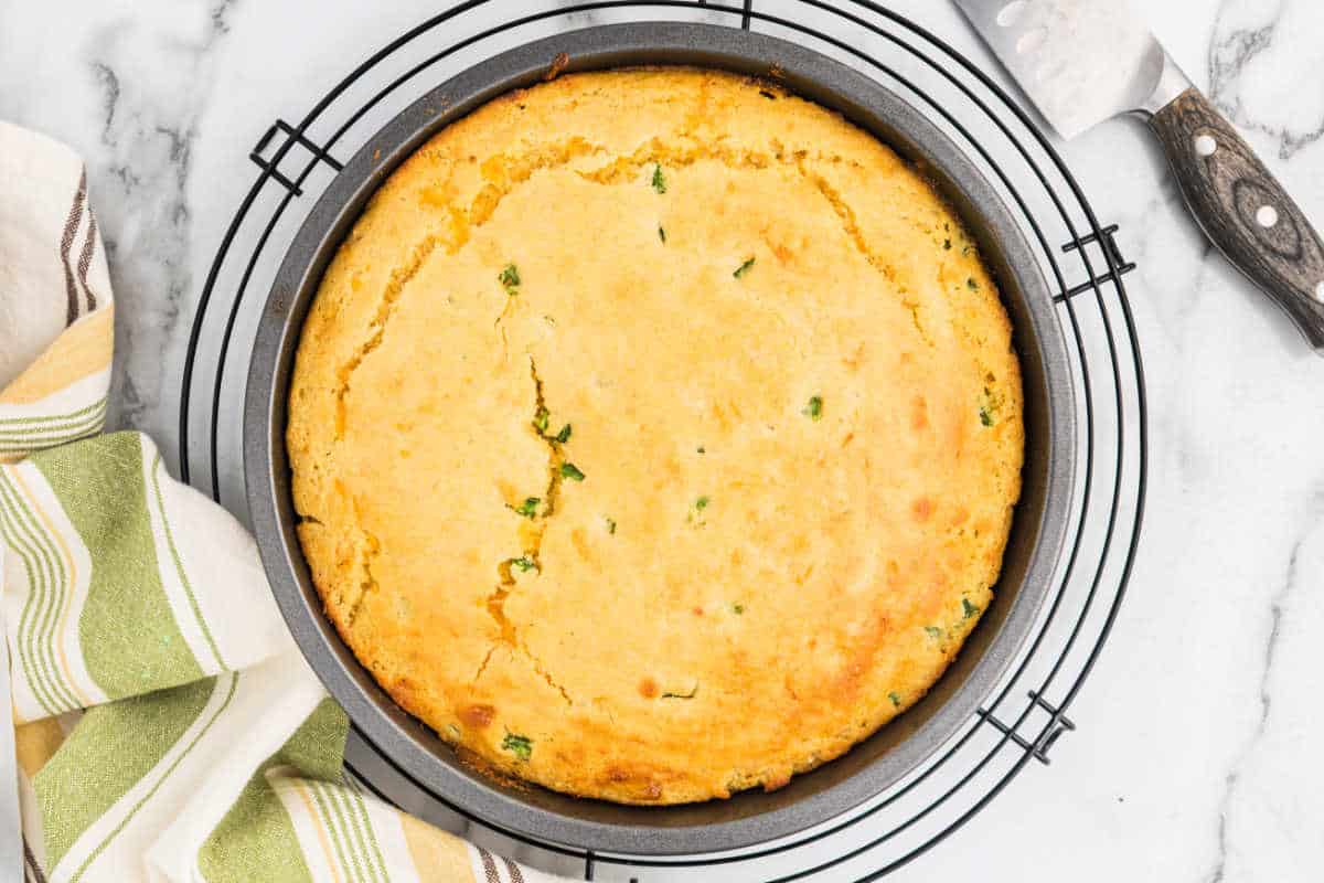 Jalapeno cheddar cornbread in a pan on a cooling rack.