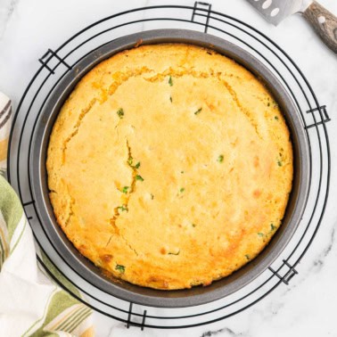 Cornbread in a pan on wire cooling rack.