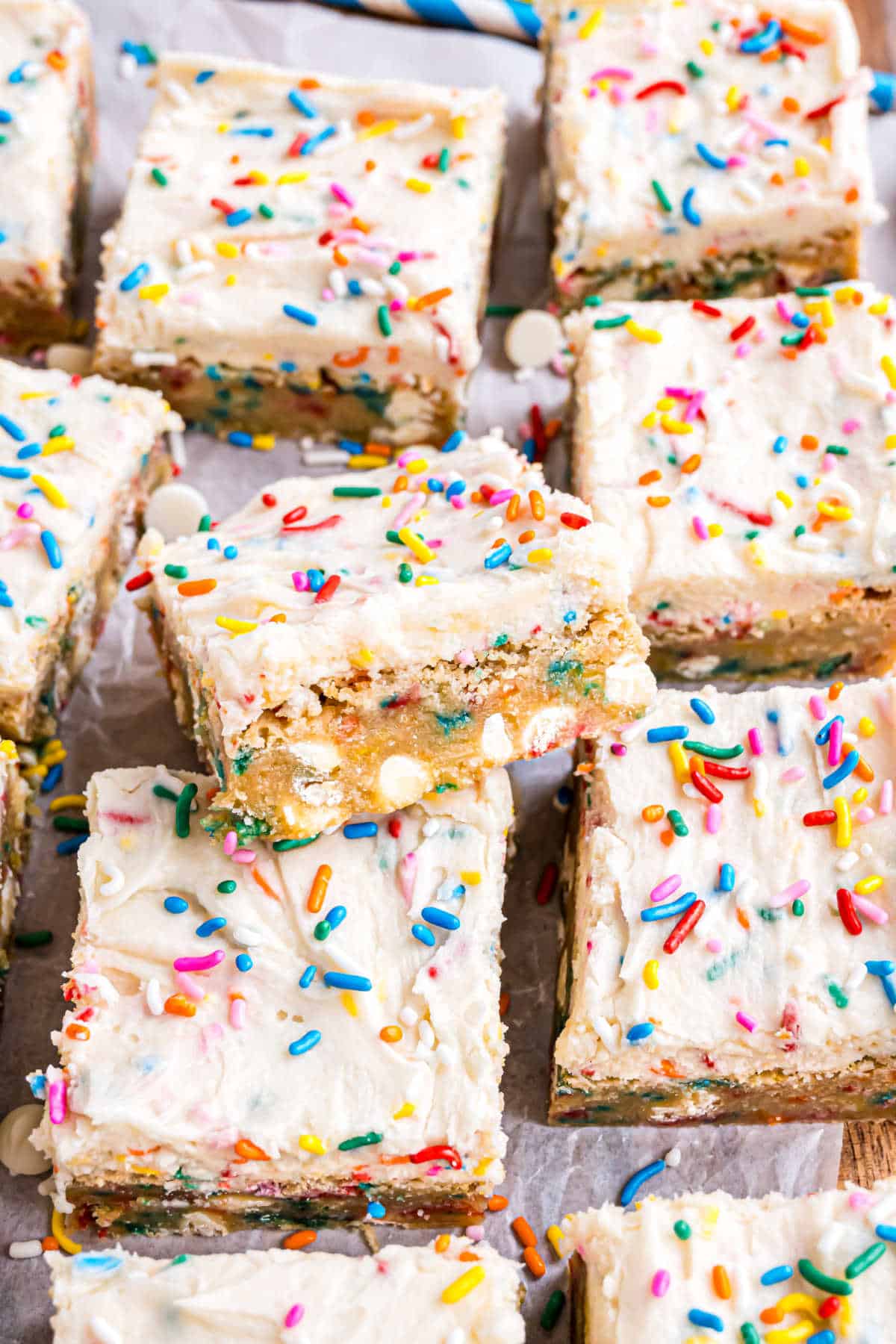 Blondies loaded with sprinkles and topped with frosting.