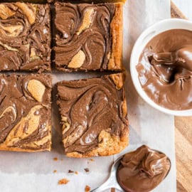 Nutella Swirled Blondies are decadence at its finest. Topped with vanilla ice cream and drizzled with melted Nutella, these blondies are fudgy, sweet and easy to make!