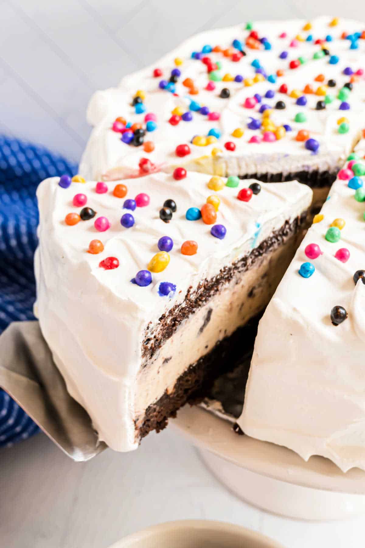 Brownie ice cream cake with a slice being removed.