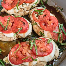 Skillet with chicken, tomatoes, cheese, and basil.