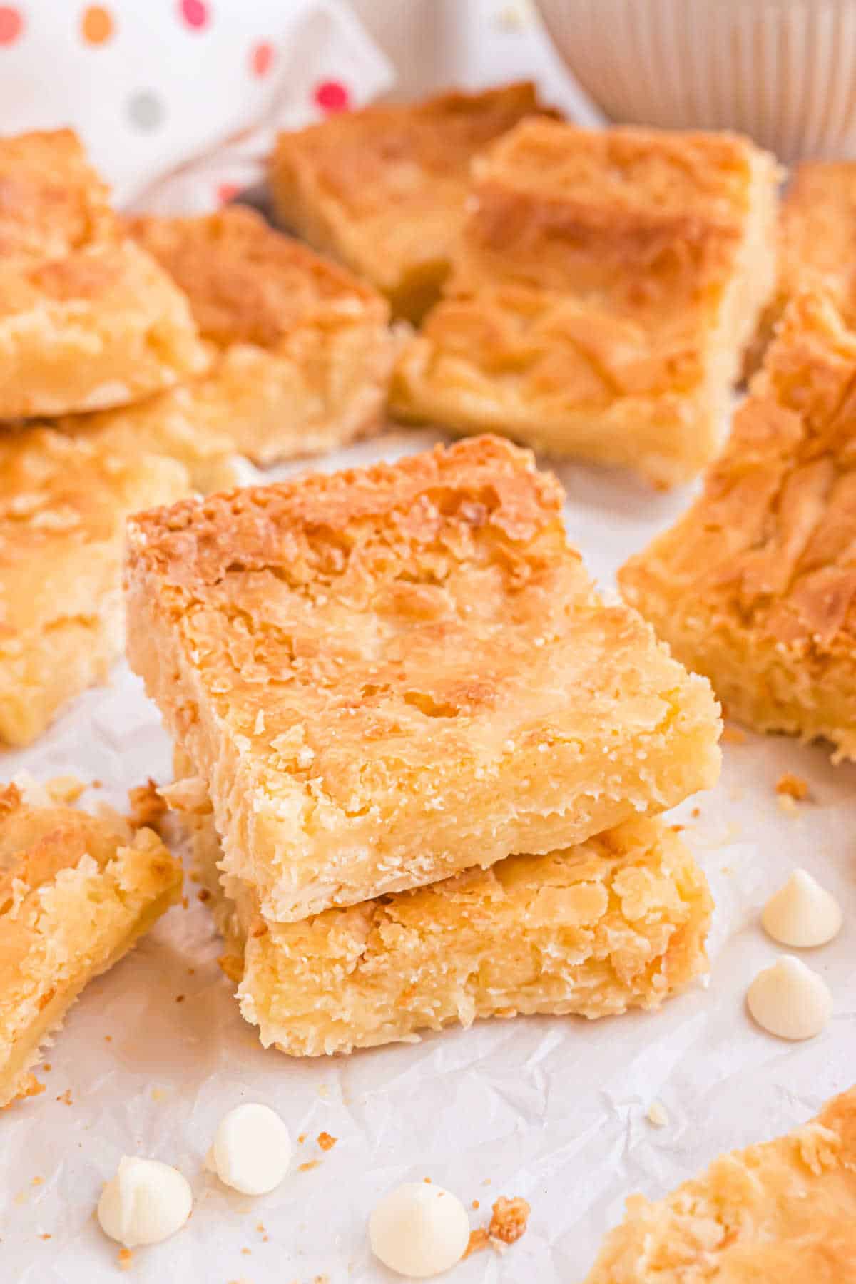 Stack of two white chocolate brownies on parchment paper.