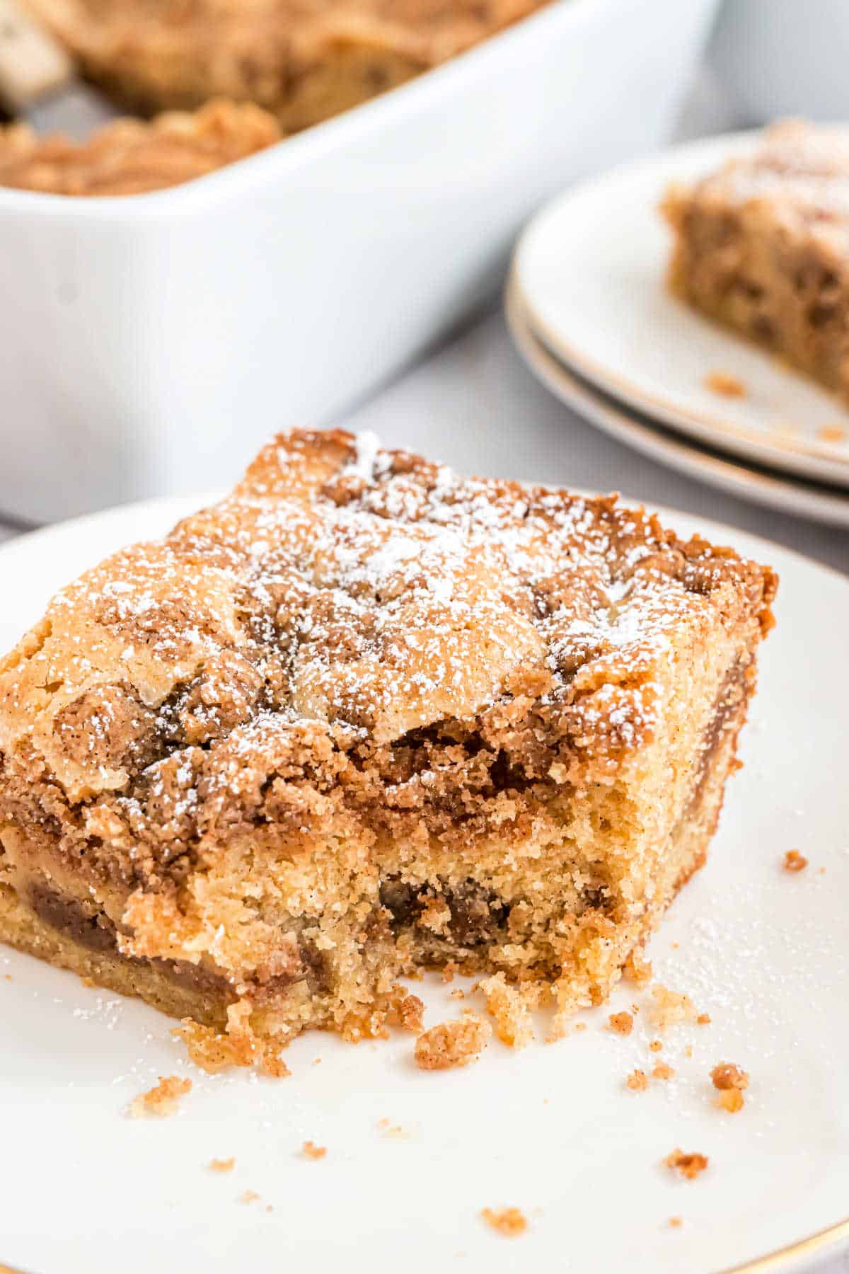 Slice of cinnamon coffee cake with a bite taken out.