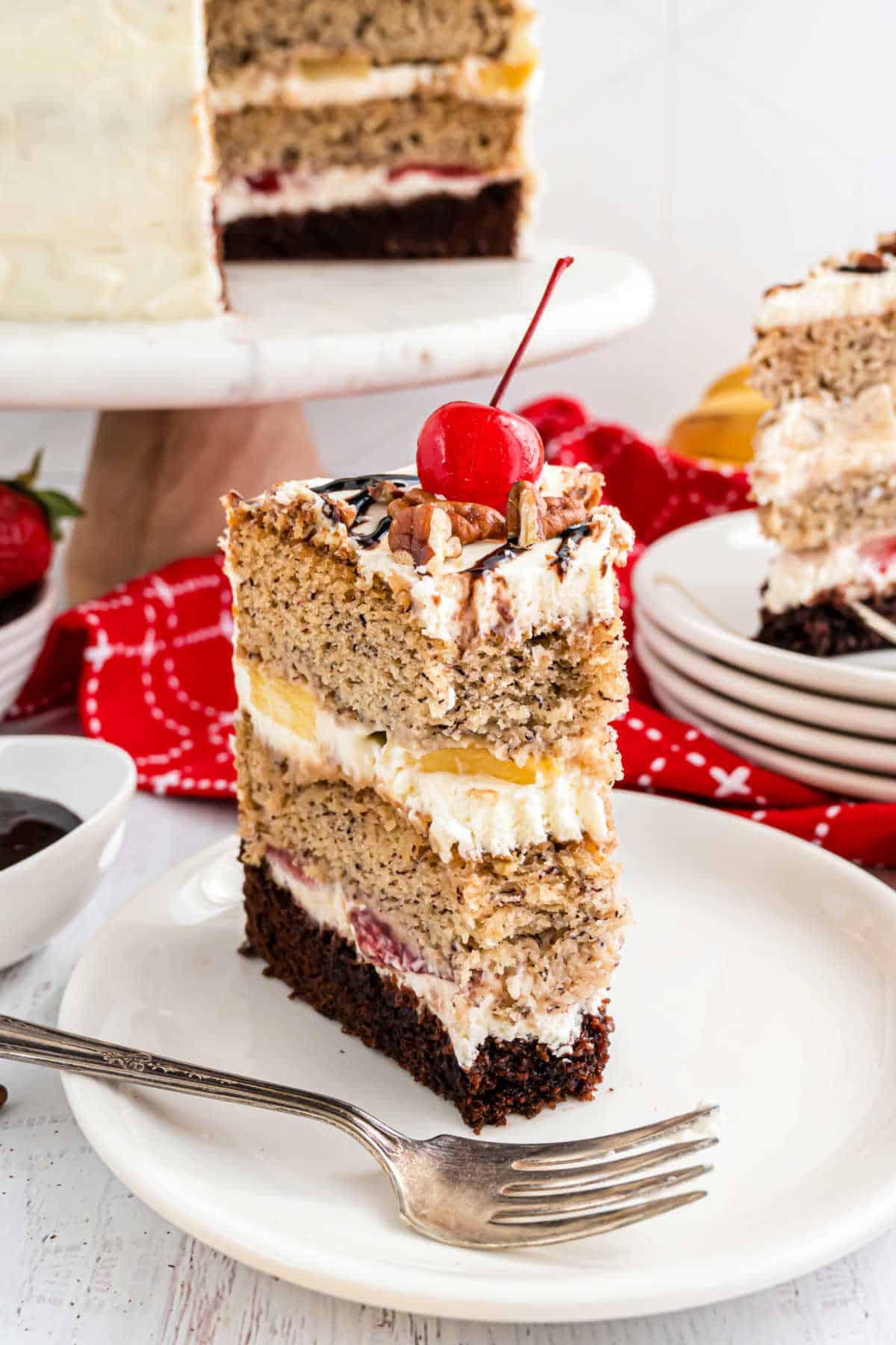 Slice of banana split cake with a bite taken out.