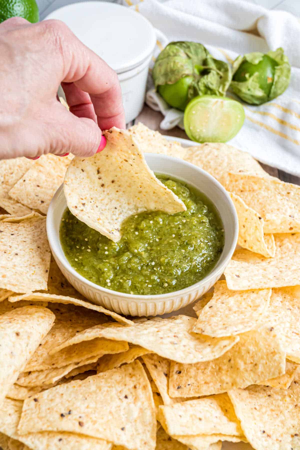 Bowl of green salsa with a tortilla chip.