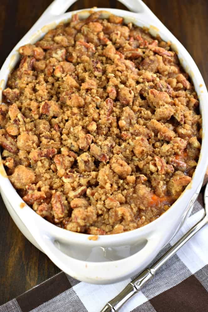 Sweet Potato Casserole met Streusel topping in een witte ovale ovenschaal.