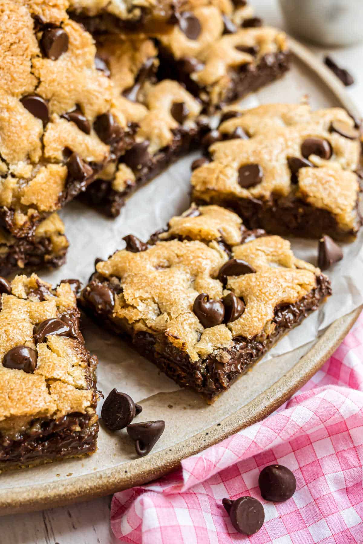 Chocolate chip cookie bar squares on a cake platter for serving.