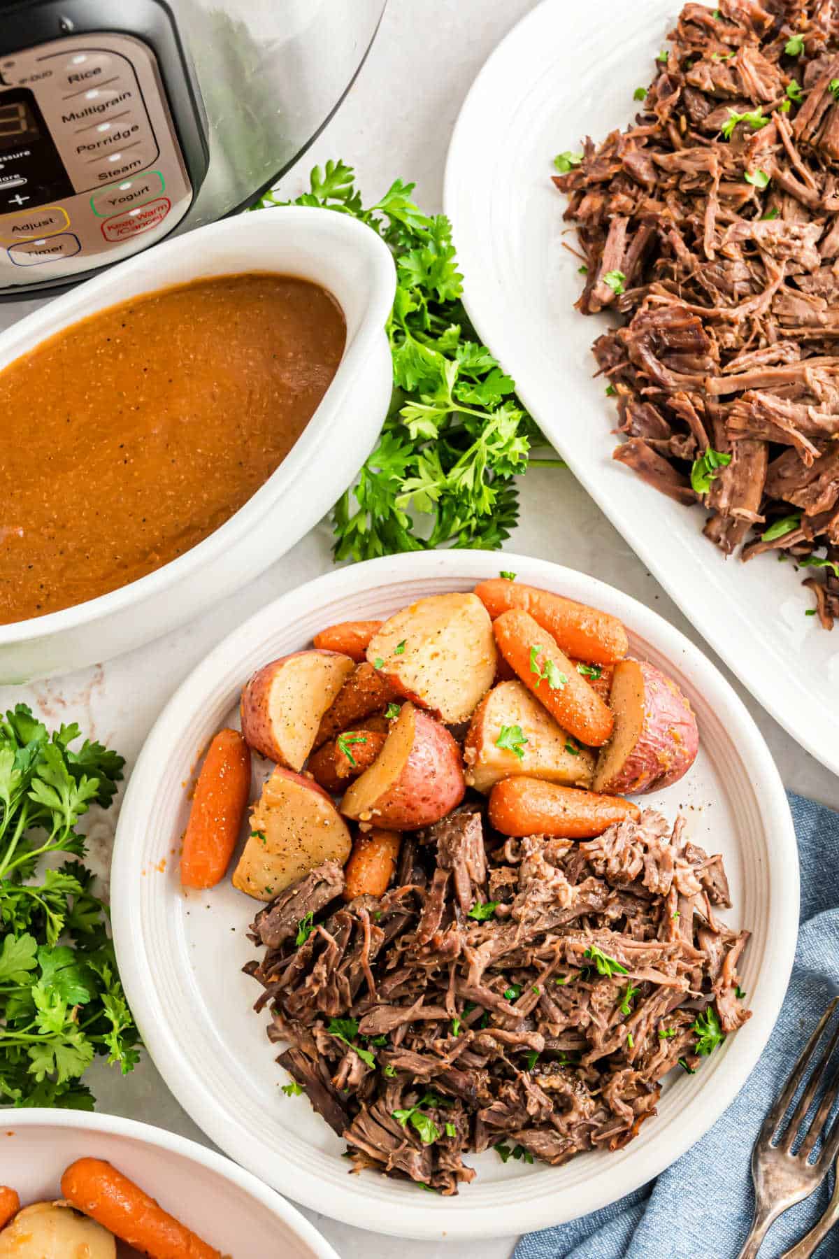 Shredded beef with a side of carrots, potatoes, and gravy.