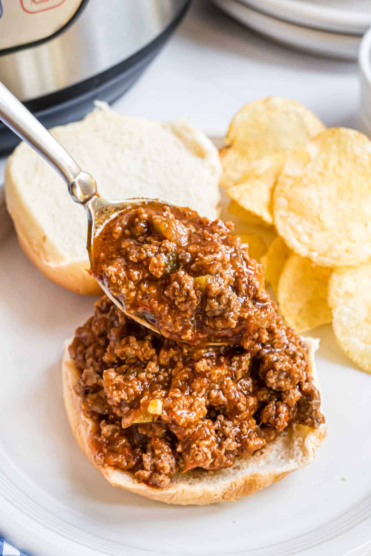 Sloppy joes being piled onto a bun.