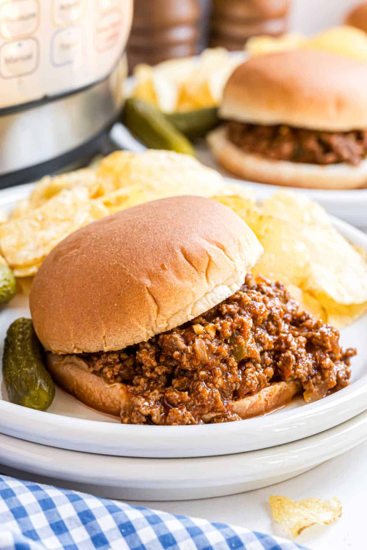 Sloppy joes on a bun served with potato chips.