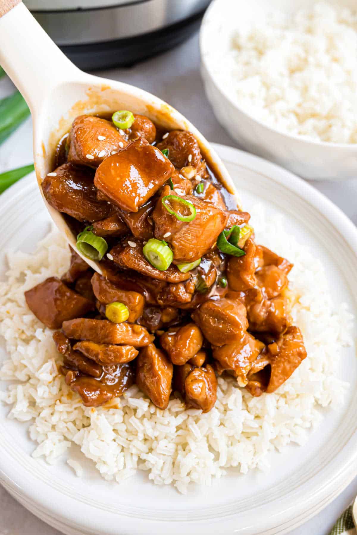 Mongolian chicken being spooned onto rice.