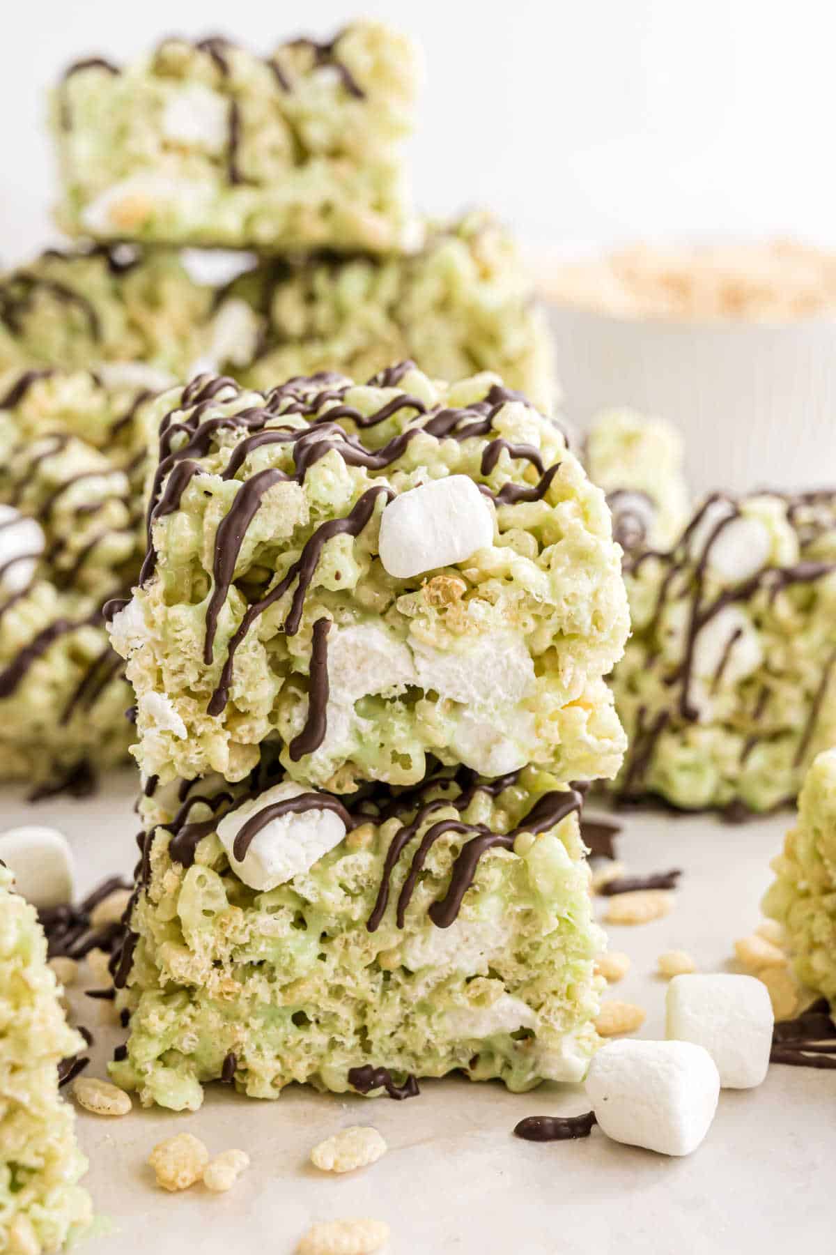 Stack of two pistachio krispie treats with chocolate drizzle.