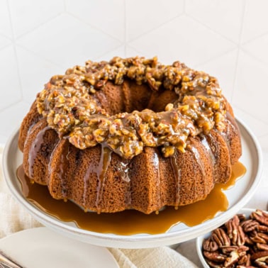 Delicious, moist cinnamon bundt cake with pecan pie filling and topped with a nutty pecan pie topping! This Pecan Pie Bundt Cake recipe is a holiday show stopper, and the perfect Thanksgiving dessert.