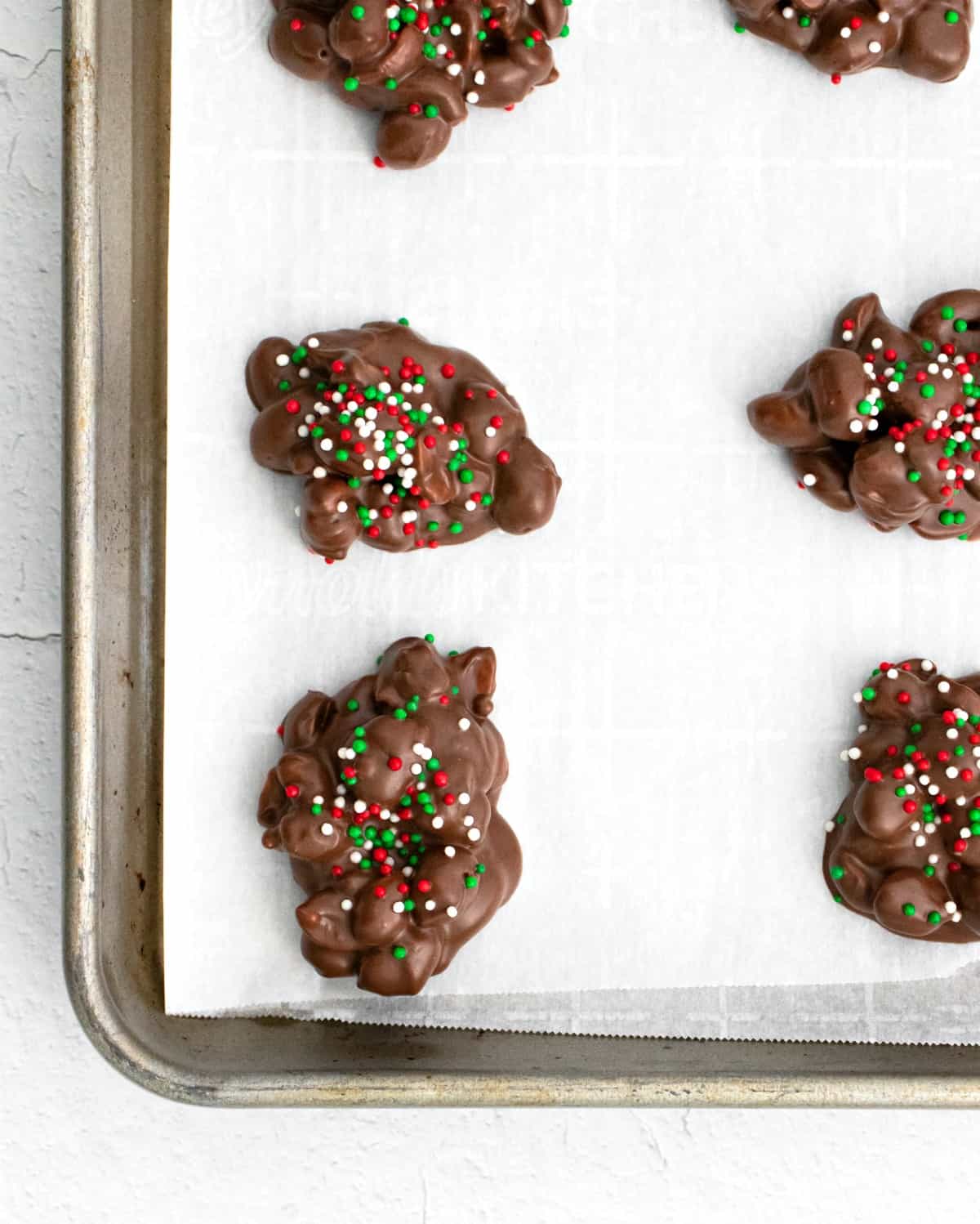 Tre ingredienti crock pot candy su carta pergamena foderato teglia.