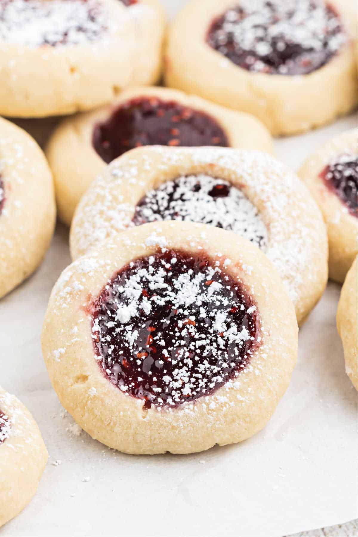 Stacked thumbpring cookies with raspberry preserves.