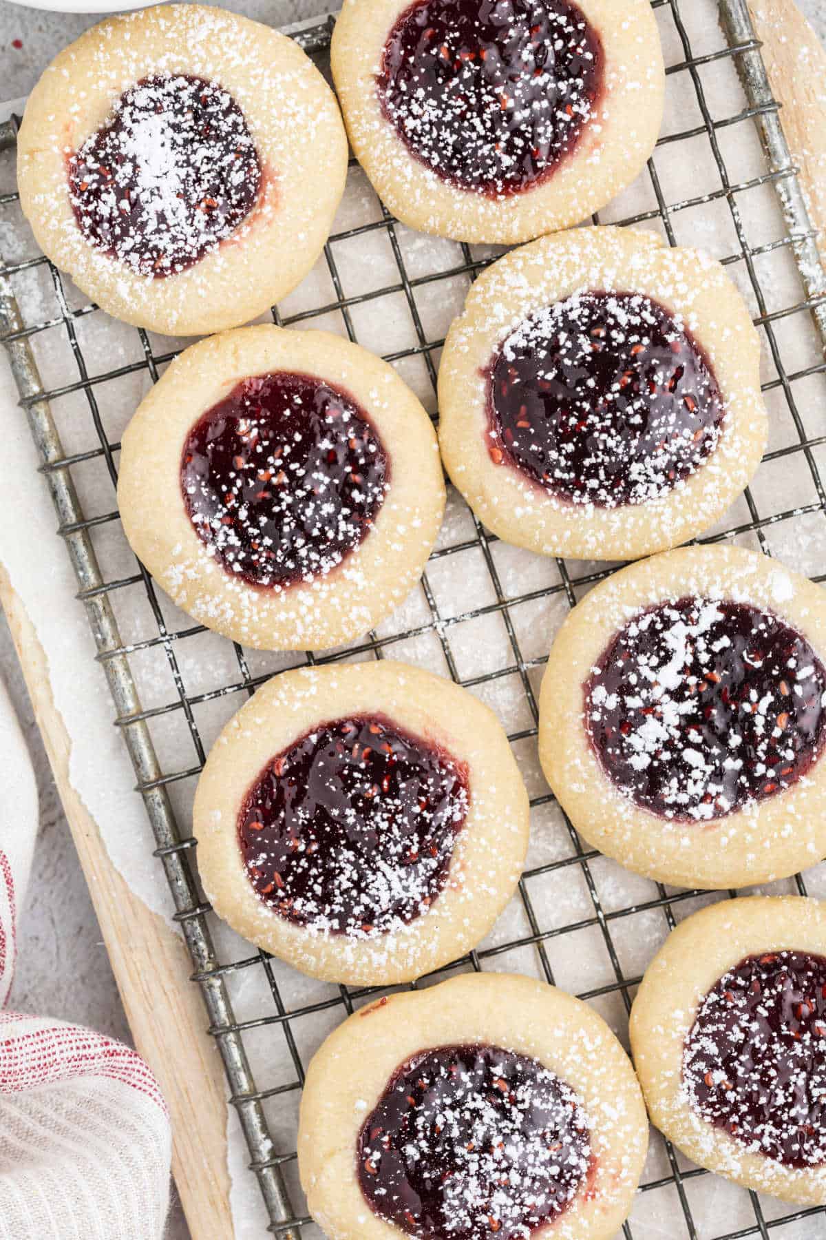 Raspberry jam cookies cooling on a wire rack.