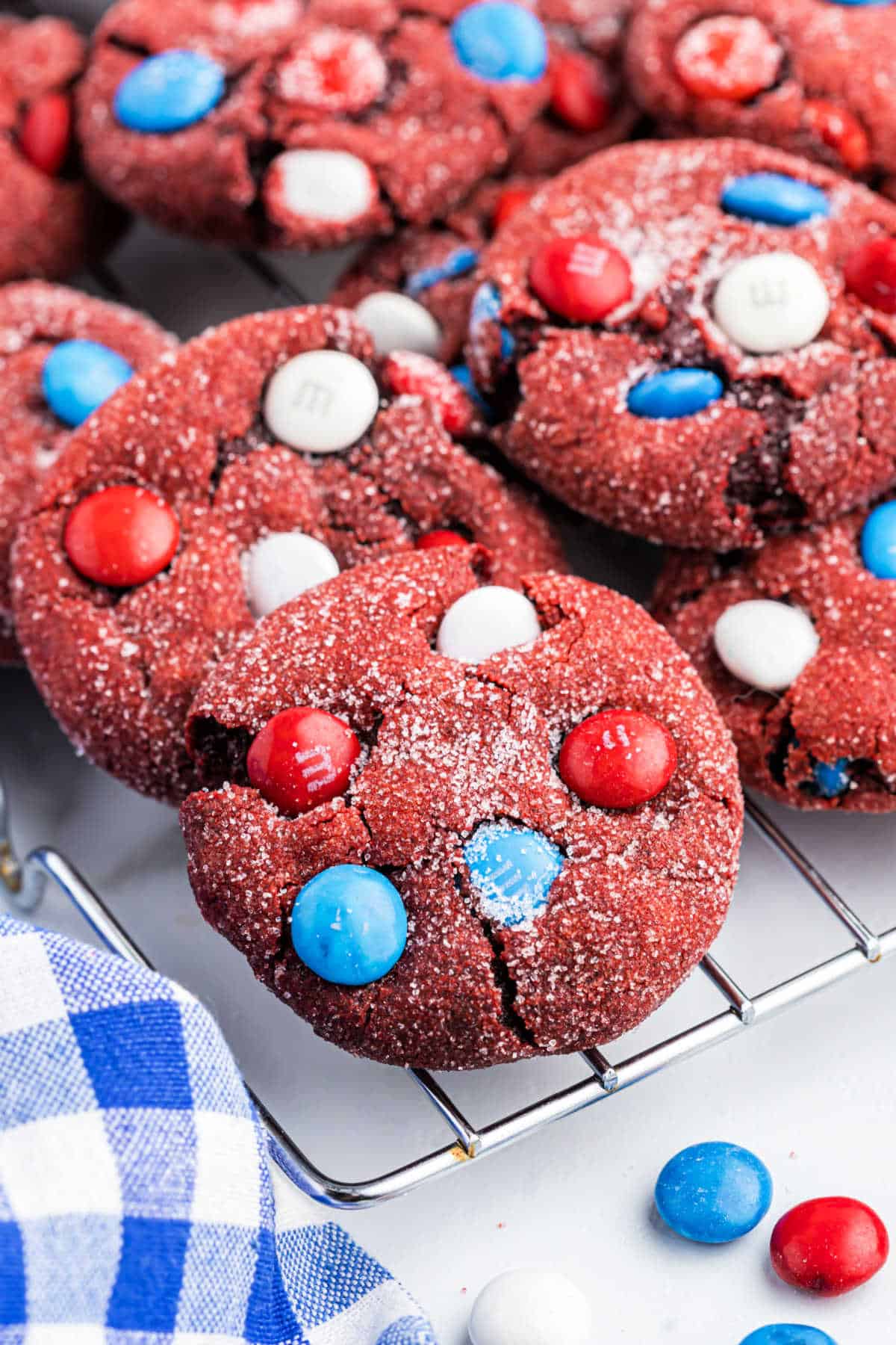 Red cookies with patriotic candy on a wire cooling rack.