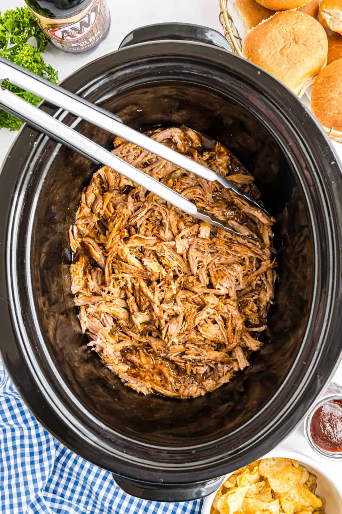 Black crockpot with shredded pulled pork.