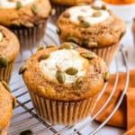 Cream cheese filled pumpkin muffins on a wire rack.