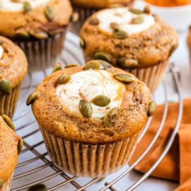 Cream cheese filled pumpkin muffins on a wire rack.