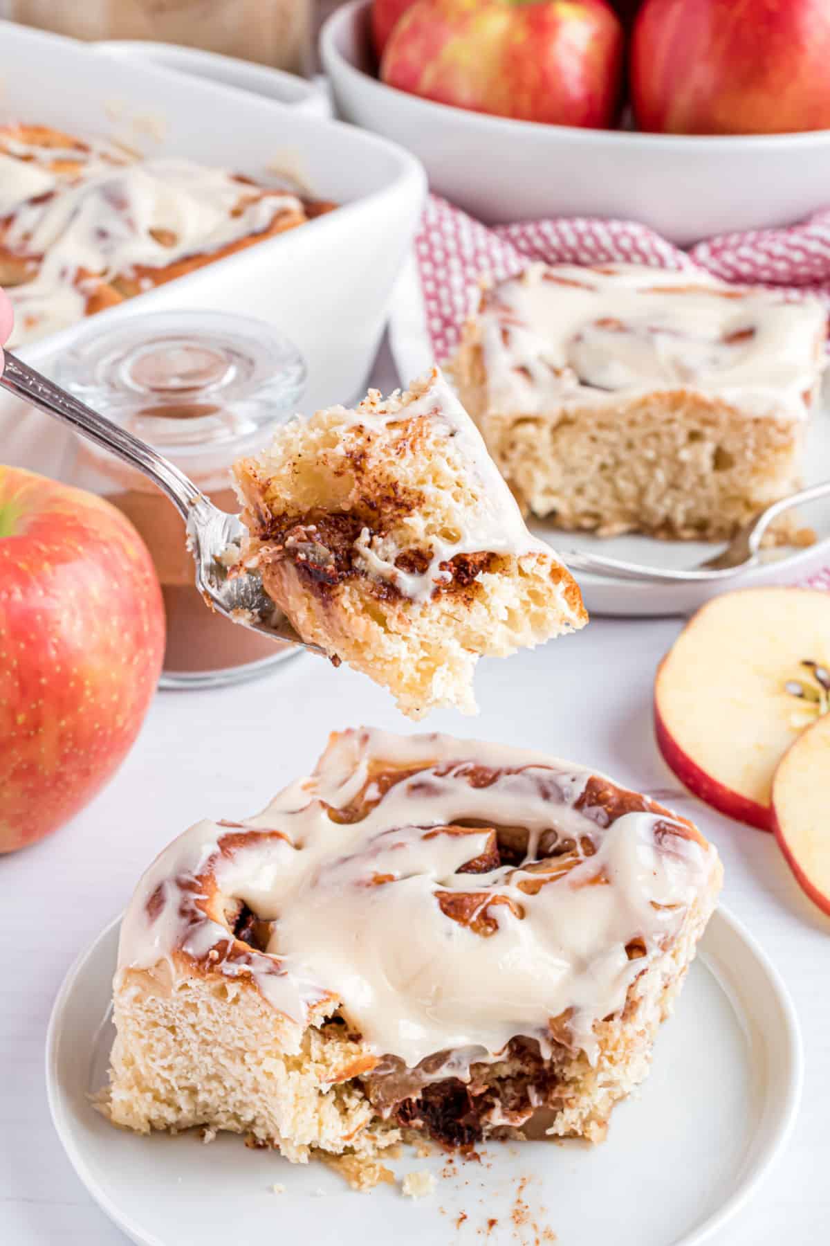 Apple cinnamon roll with one forkful being removed.