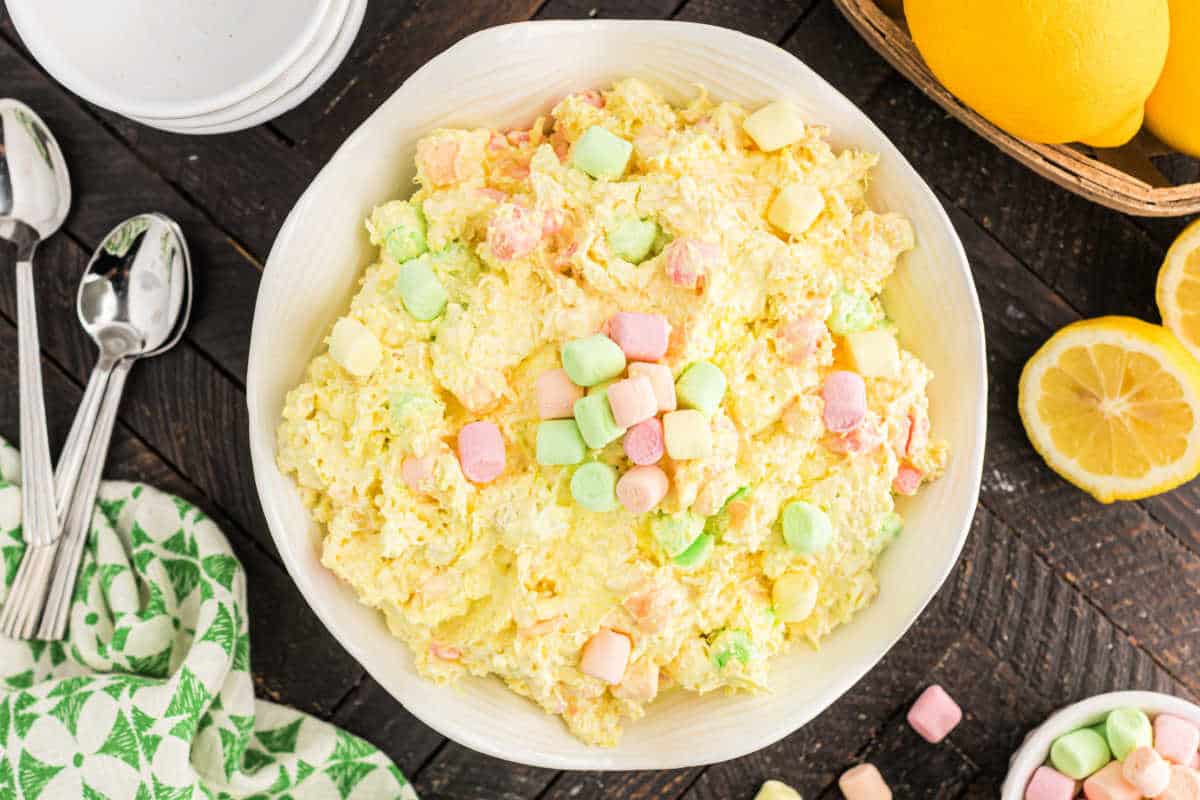 Bowl of lemon jello salad with fruity marshmallows on top.