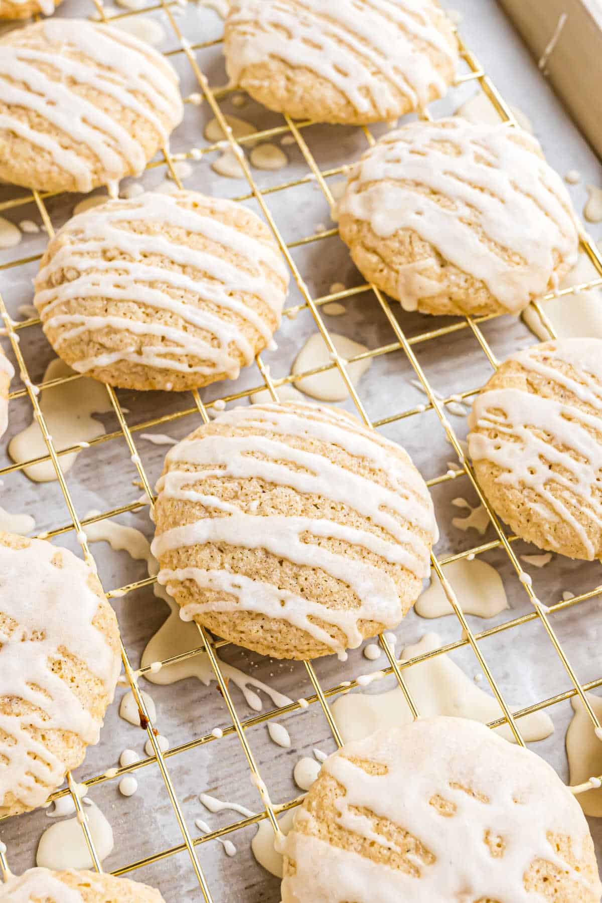 Eggnog cookies on a wire rack drizzled with eggnog icing.