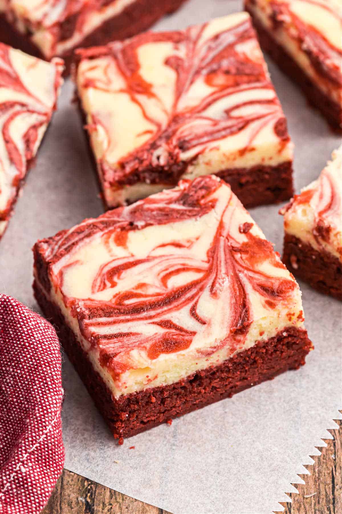 Red velvet brownies with a cheesecake swirl cut into squares.