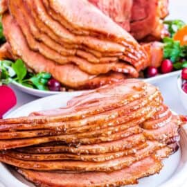 Slices of honey baked ham served on a white plate.