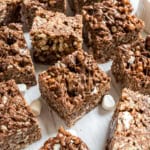 Hazelnut krispie treats cut into bars on parchment paper.