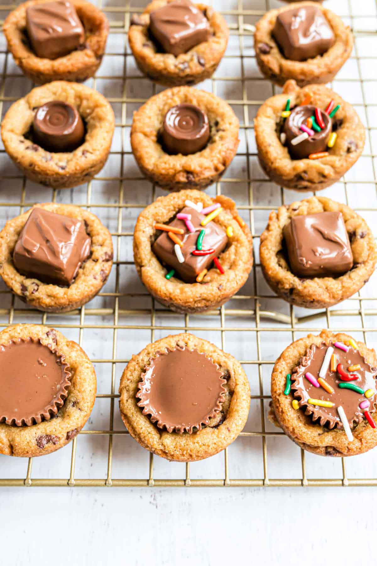 Chocolate chip cookies baked in a muffin tin on a wire rack.