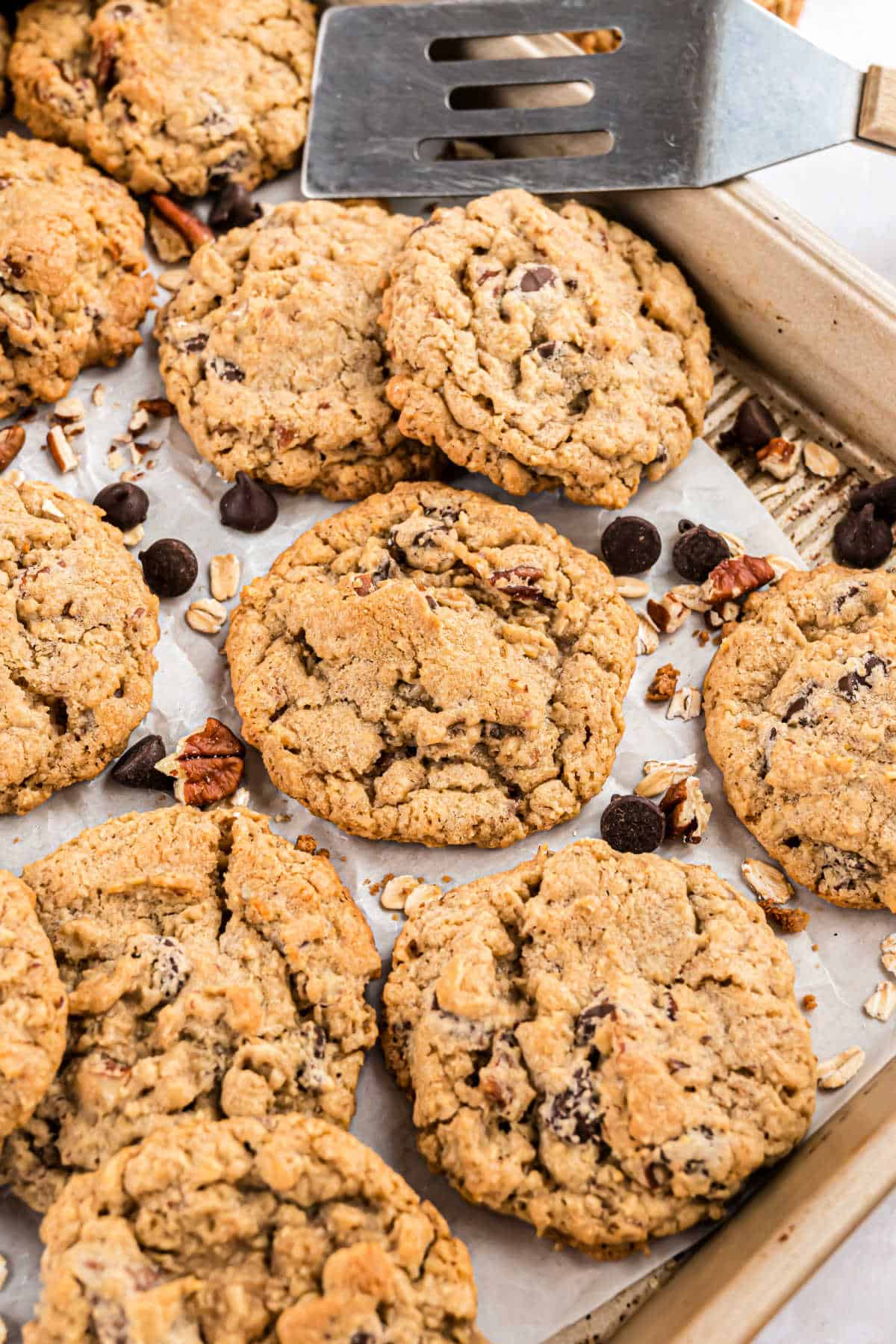 Chocolate chip pecan cookies on a parchment paper lined cookie sheet.