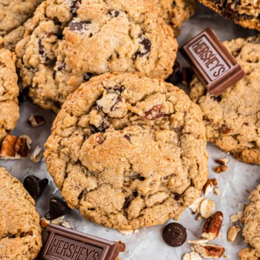 Chocolate chip cookie with pecans on parchment paper.