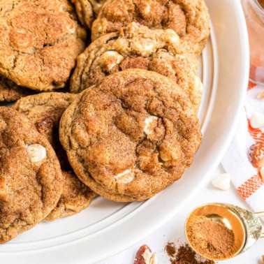 Pumpkin cookies with white chocolate and pecans on serving plate.