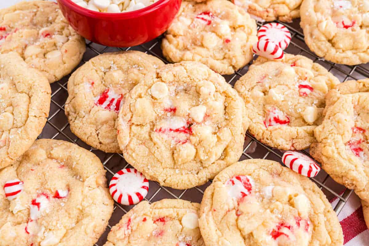 Peppermint white chocolate cookies stacked on a wire rack.