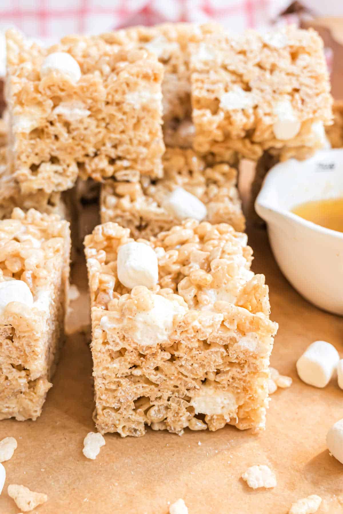 Squares of brown butter rice krispie treats on parchment paper.