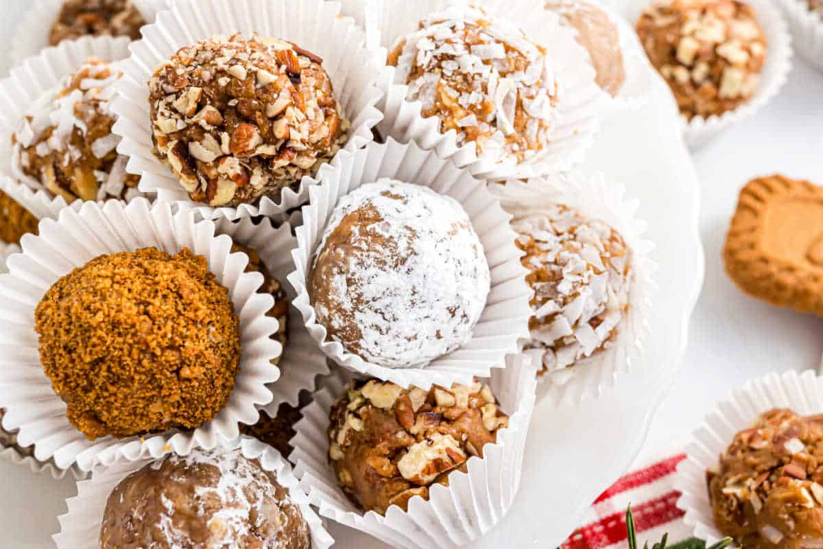 Rum balls stacked on a white platter.