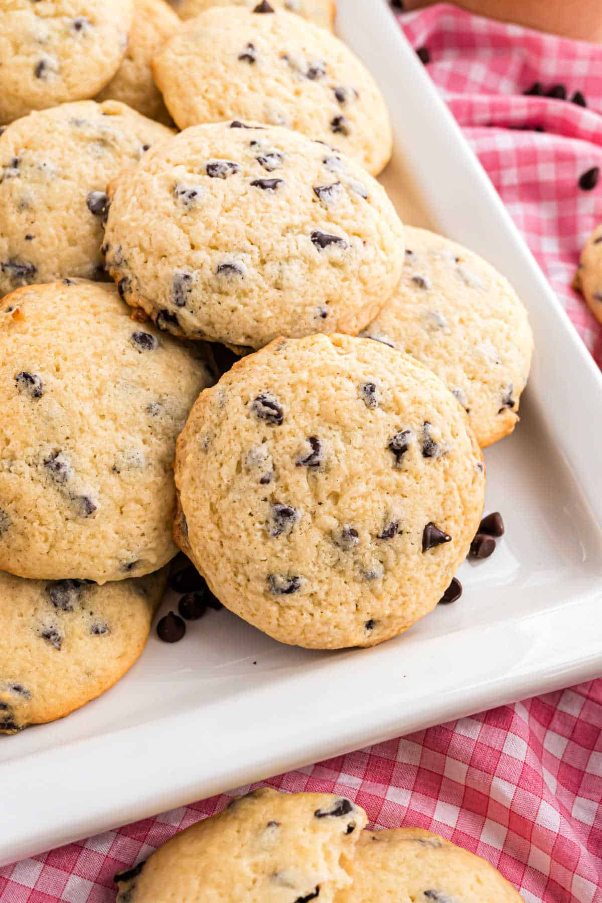 Chocolate chip ricotta cookies stacked on a white square plate.