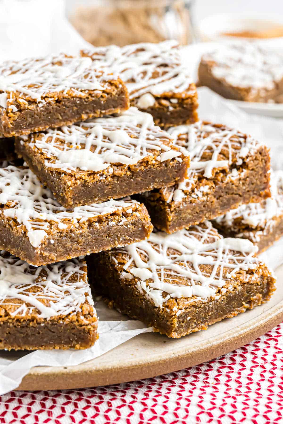 Stack of gingerbread blondies with white chocolate on a serving plate.