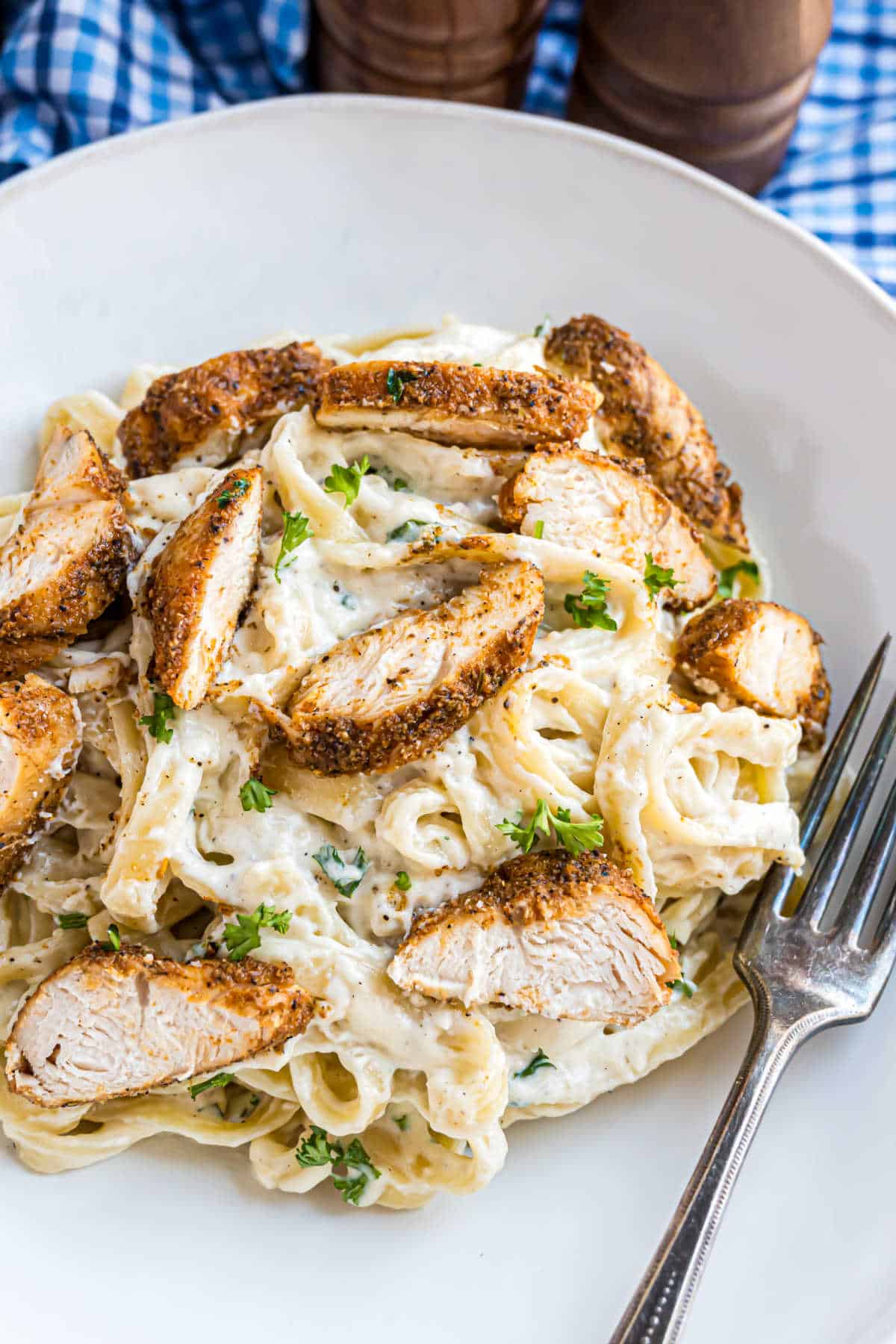 Alfredo pasta topped with blackened chicken tenders.