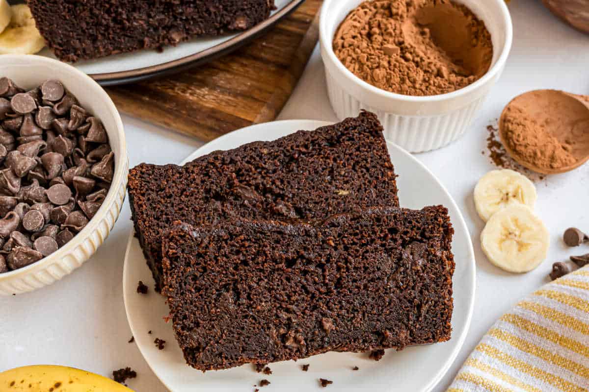 Two slices of chocolate bread on a white plate.