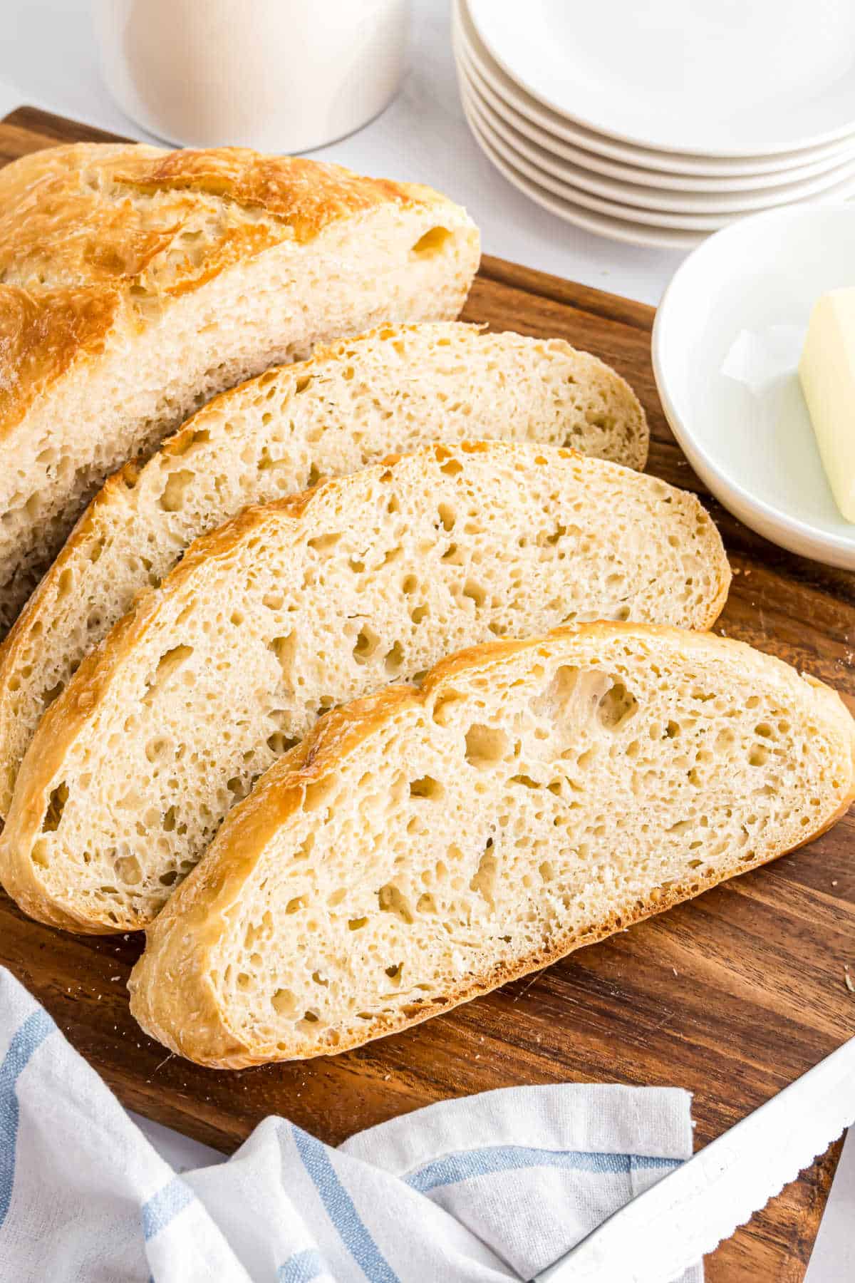 Artisan bread sliced and served on a wooden cutting board.