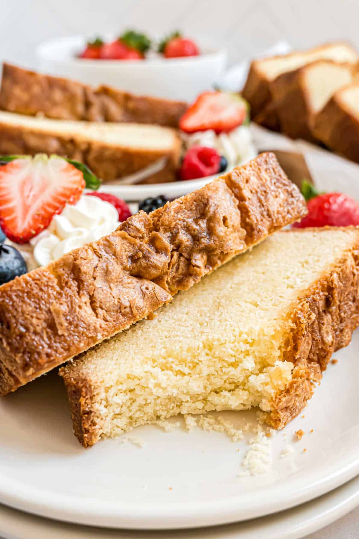 Two slices of pound cake on a plate with a bite taken out.