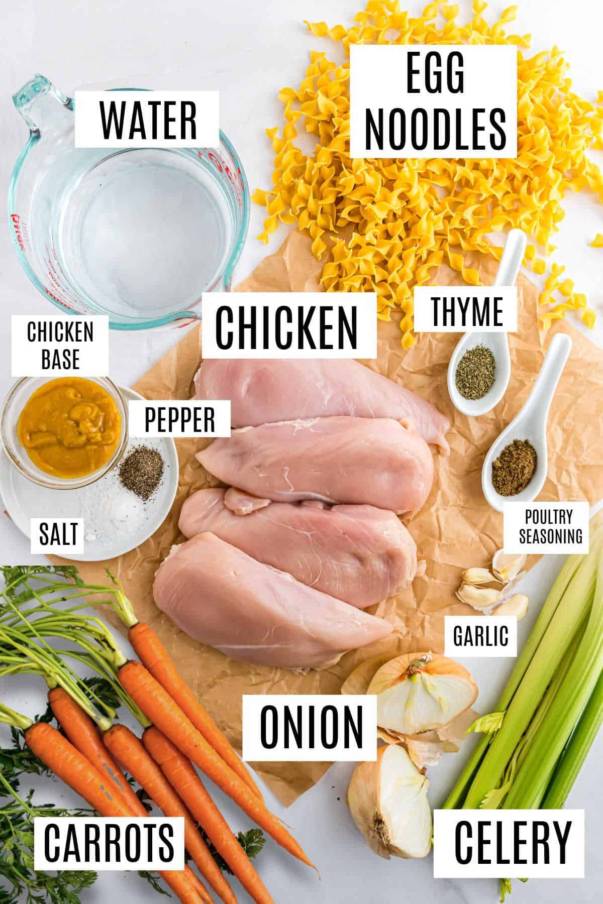 Ingredients for a hearty chicken noodle soup: tender chicken, egg noodles, vibrant carrots, crisp celery, fragrant onion, aromatic seasonings, garlic cloves, rich chicken base, and water.