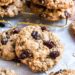 Oatmeal raisin cookies stacked on parchment paper.